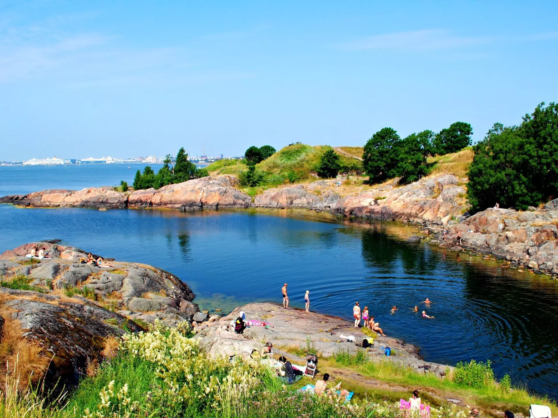 A sheltered bay with swimmers in the water.
