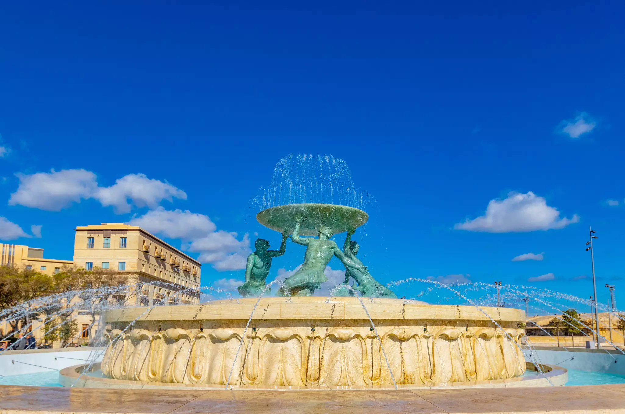 The Triton fountain, with three bronze Tritons holding up a huge basin, in front of the City Gate in Valletta