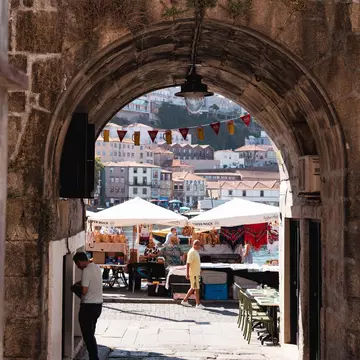 A riverfront market seen through an open stone entrance