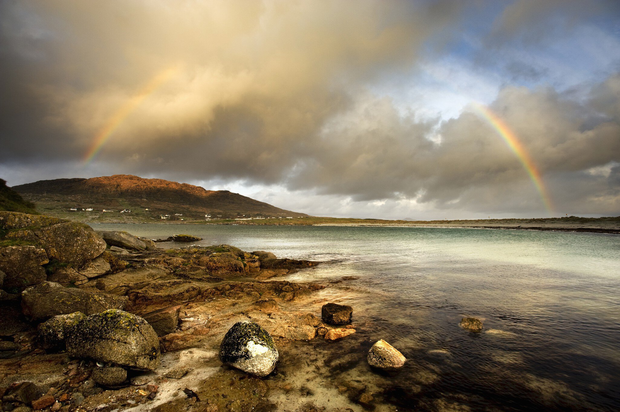 Rainbow stretching over still rural lake