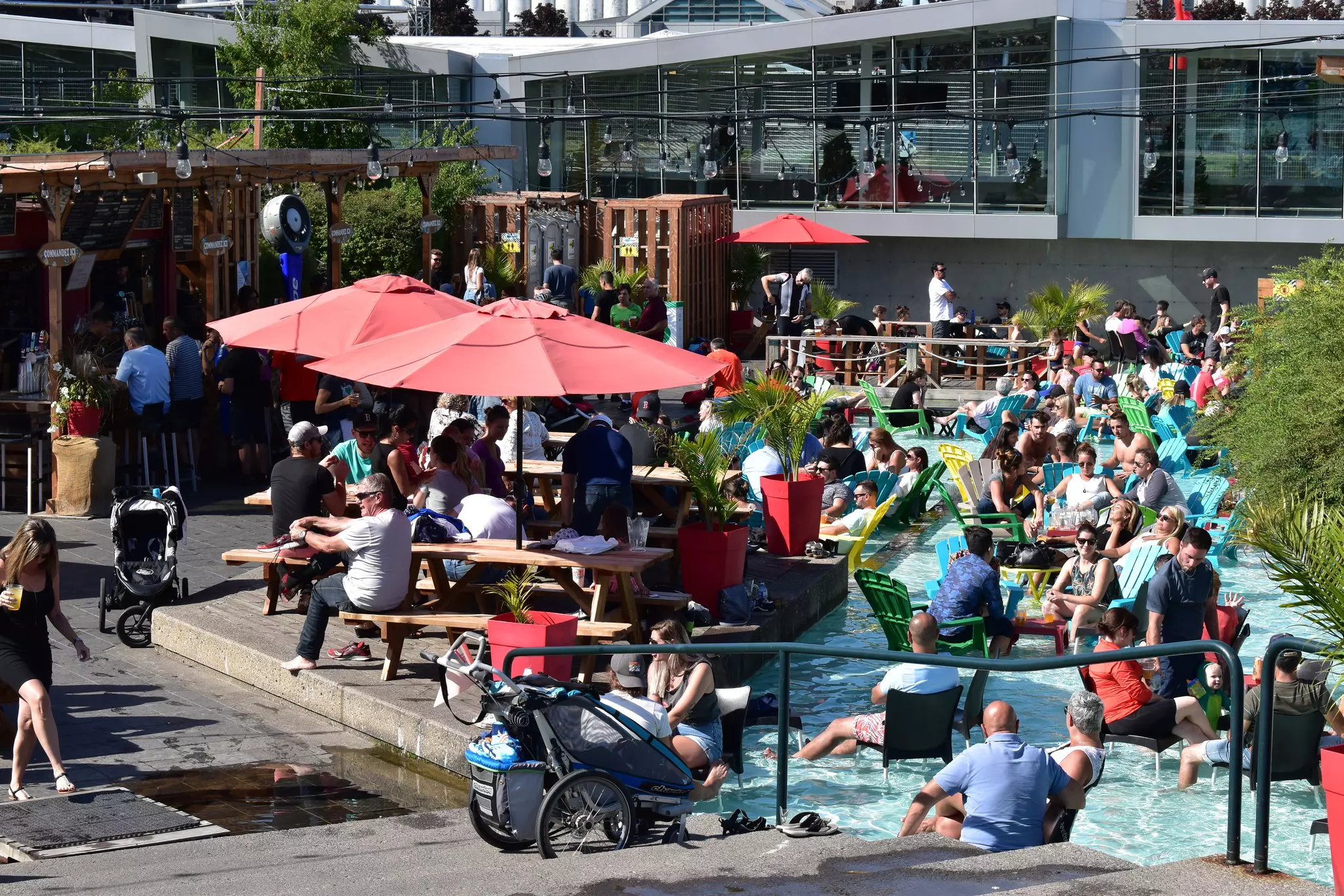 People having drinks on the terrace and enjoying the splash pool in Le Festibière de Québec in the heart of the Vieux-Port
