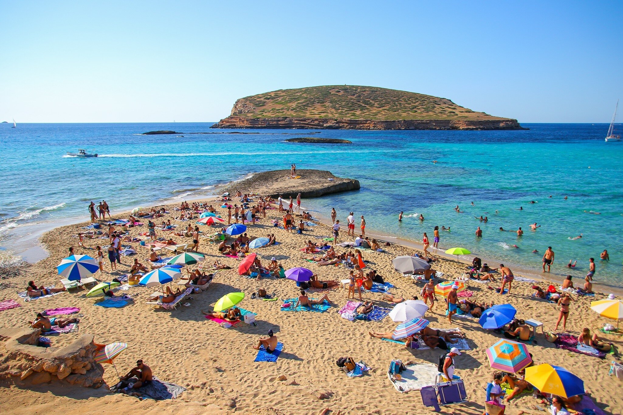 Ibiza, Spain - July 18, 2021 : Tourists sunbathing by the Mediterranean Sea on the Platges de Comte ("Comte Beaches") on the northwestern coast of Ibiza in the Balearic islands; Shutterstock ID 2292009389;