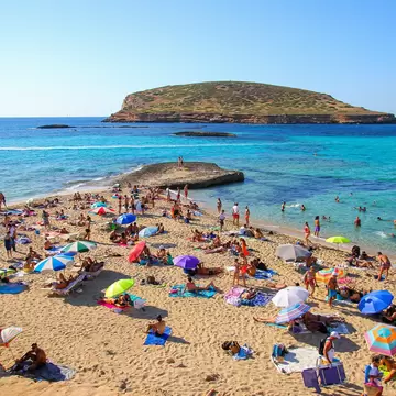 Ibiza, Spain - July 18, 2021 : Tourists sunbathing by the Mediterranean Sea on the Platges de Comte ("Comte Beaches") on the northwestern coast of Ibiza in the Balearic islands; Shutterstock ID 2292009389;