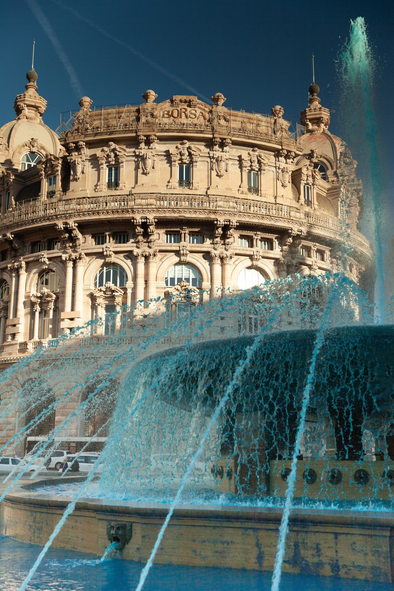 Piazza De Ferrari as the fountain spurts clear blue water.