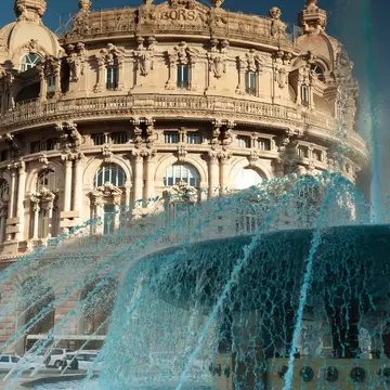 Piazza De Ferrari as the fountain spurts clear blue water.