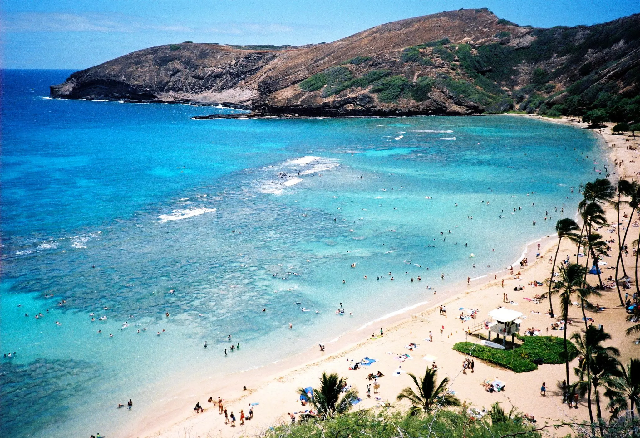 Snorkelers and beach-goers in a stunning turquoise bay