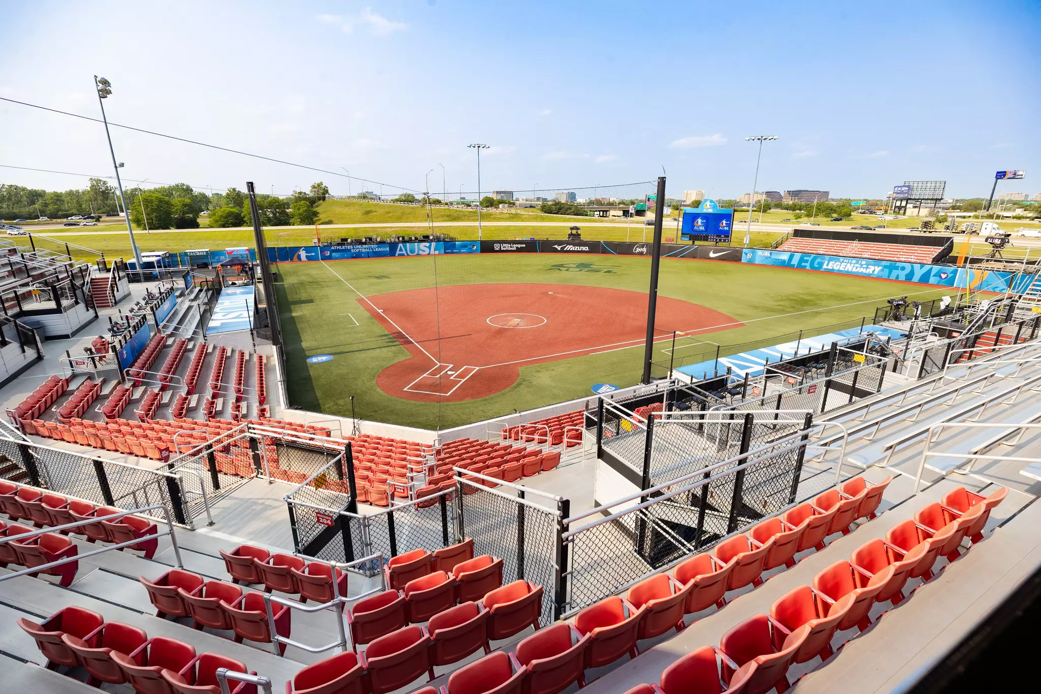 A softball pitch marked out on a sports field within a small stadium.