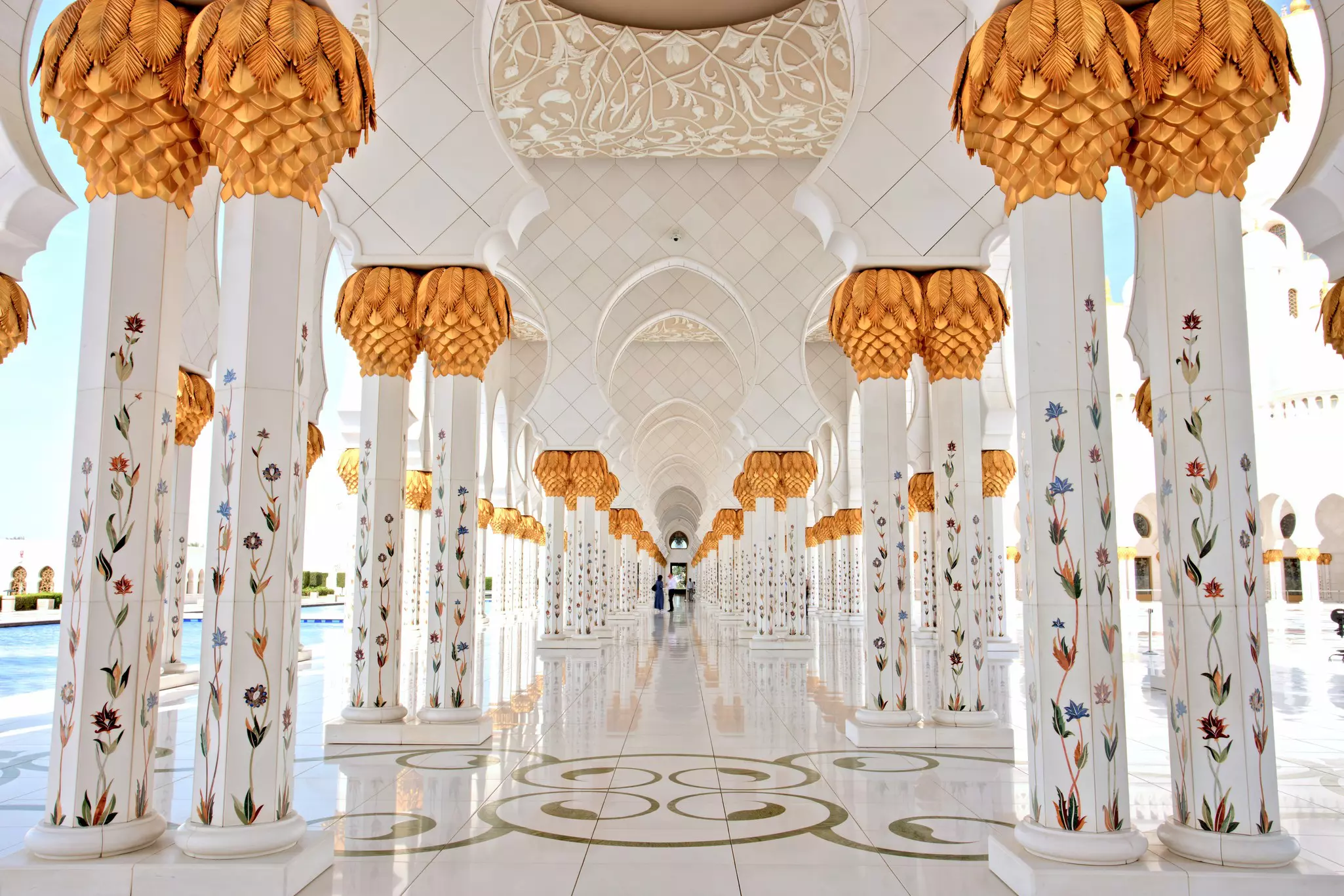 Elaborate columns, made of white marble with patterns of inlaid stones, form a corridor