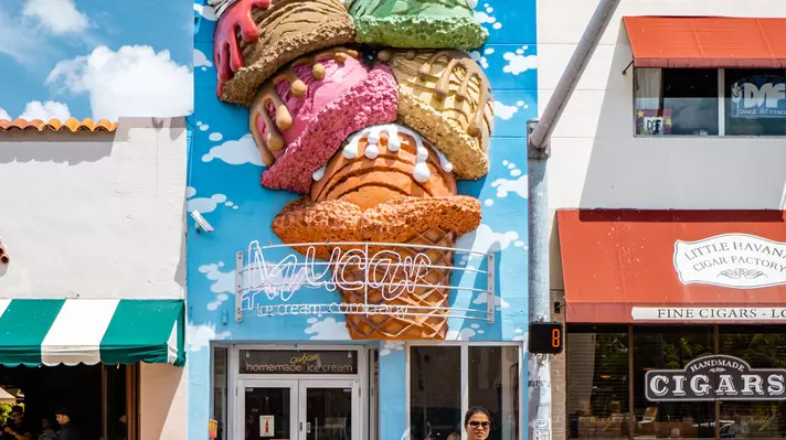 An ice cream shop with art on the exterior walls.