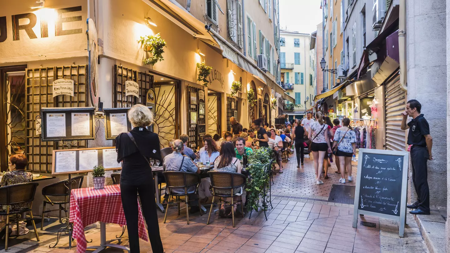 People are seated outside a restaurant in the evening in Vieux Nice, France