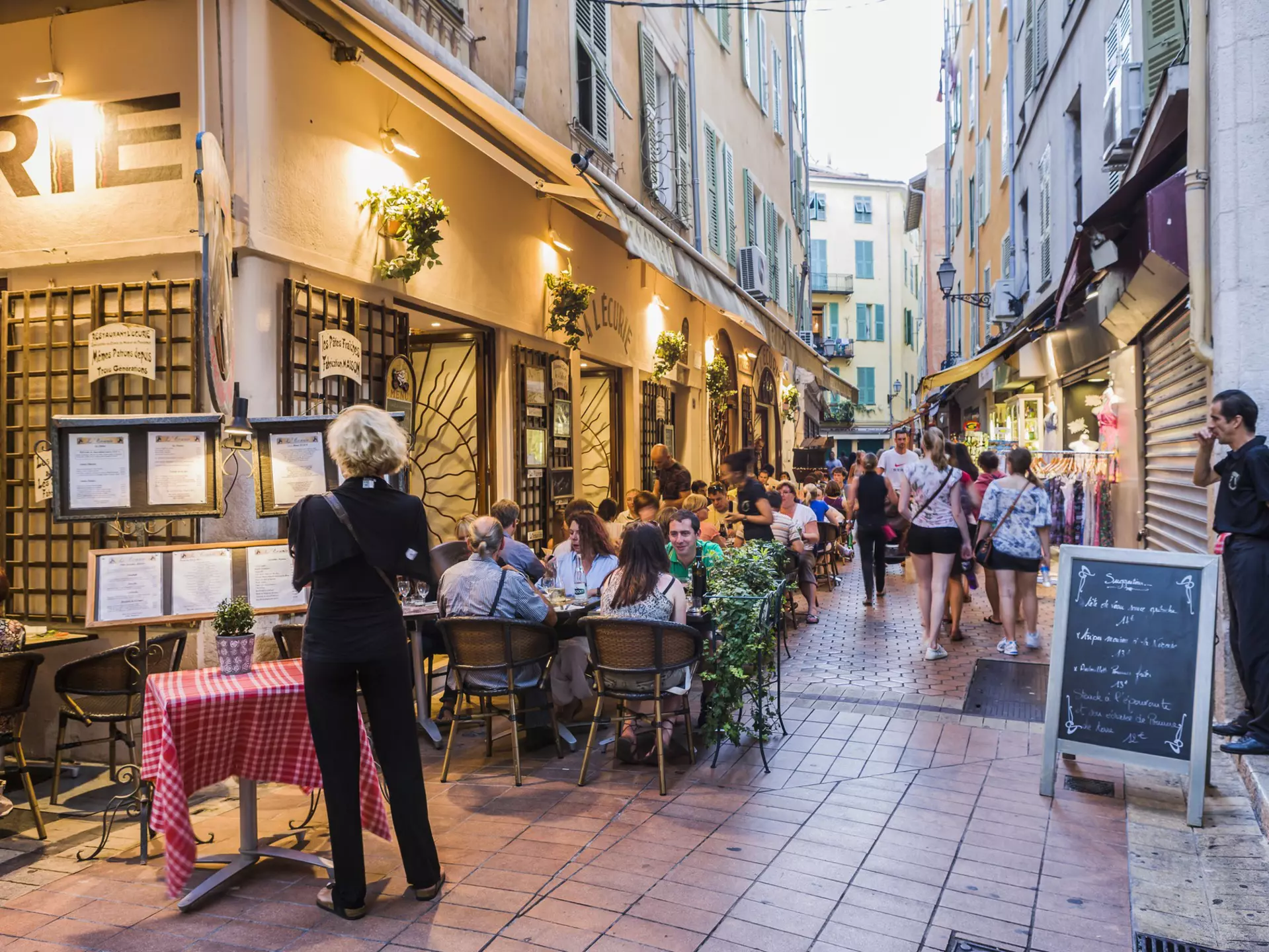 People are seated outside a restaurant in the evening in Vieux Nice, France