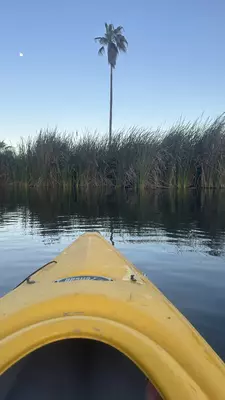 Yellow kayak on calm water at sunset. 