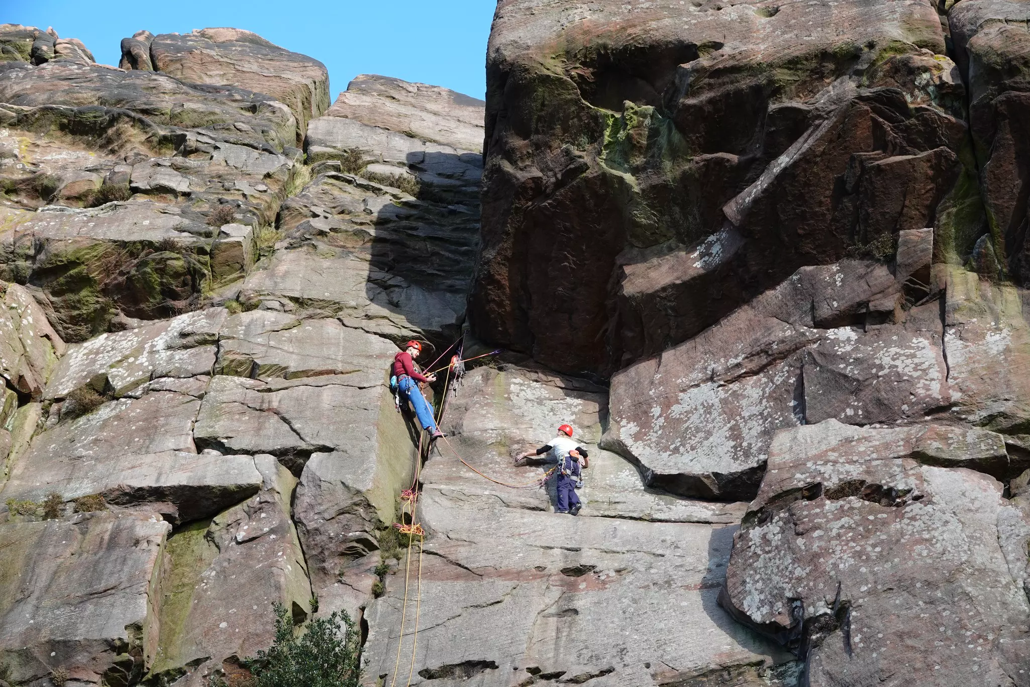 People are pictured climbing on a rock face.