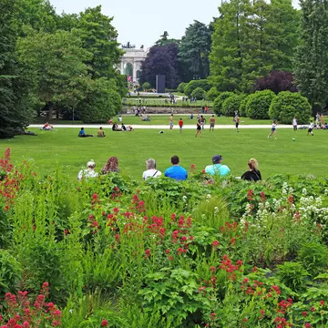 Visitors resting and playing in Sempione Park during the late afternoon.