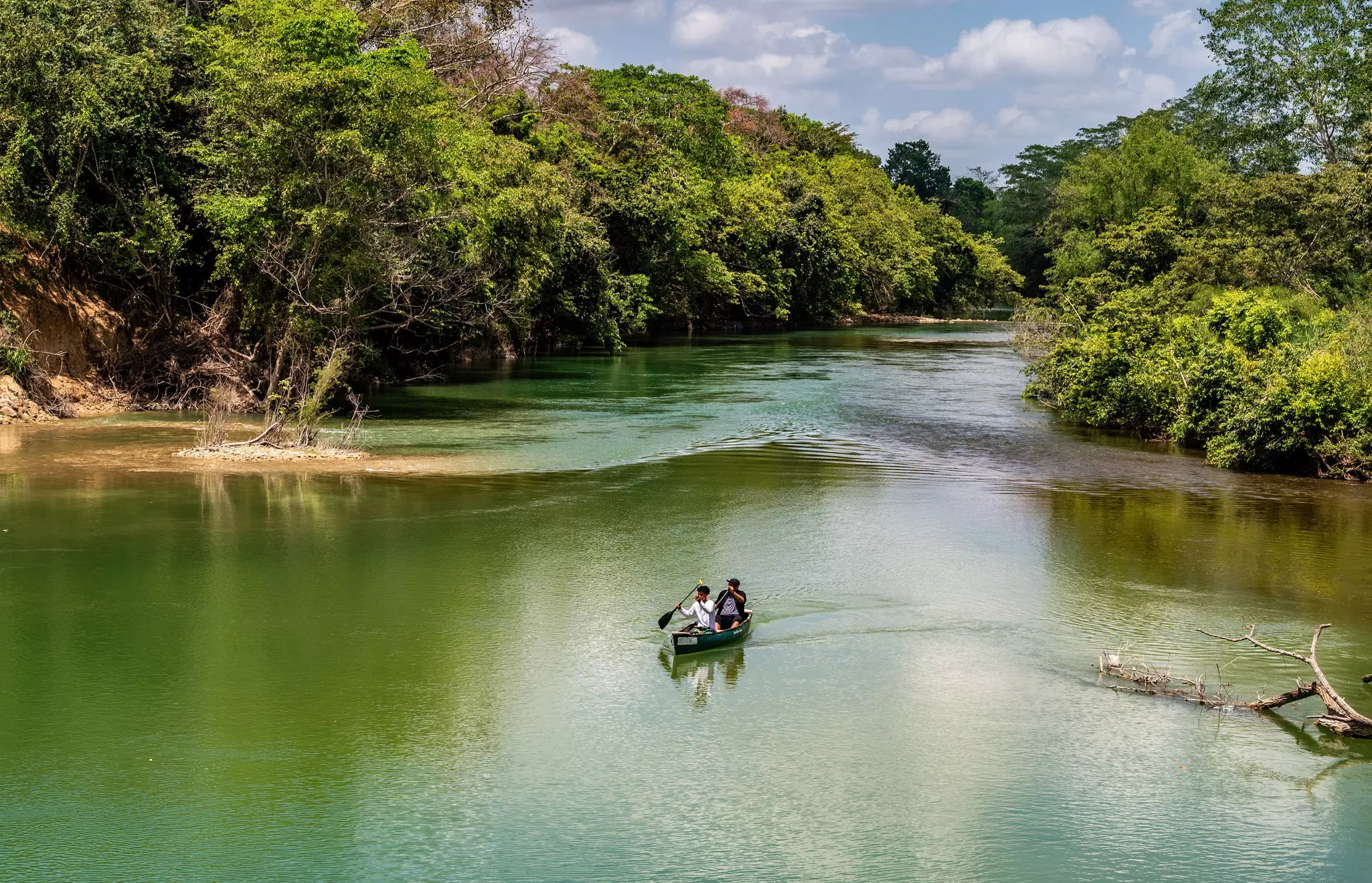 People canoeing down a jungle river near San Ignacio, Belize. 