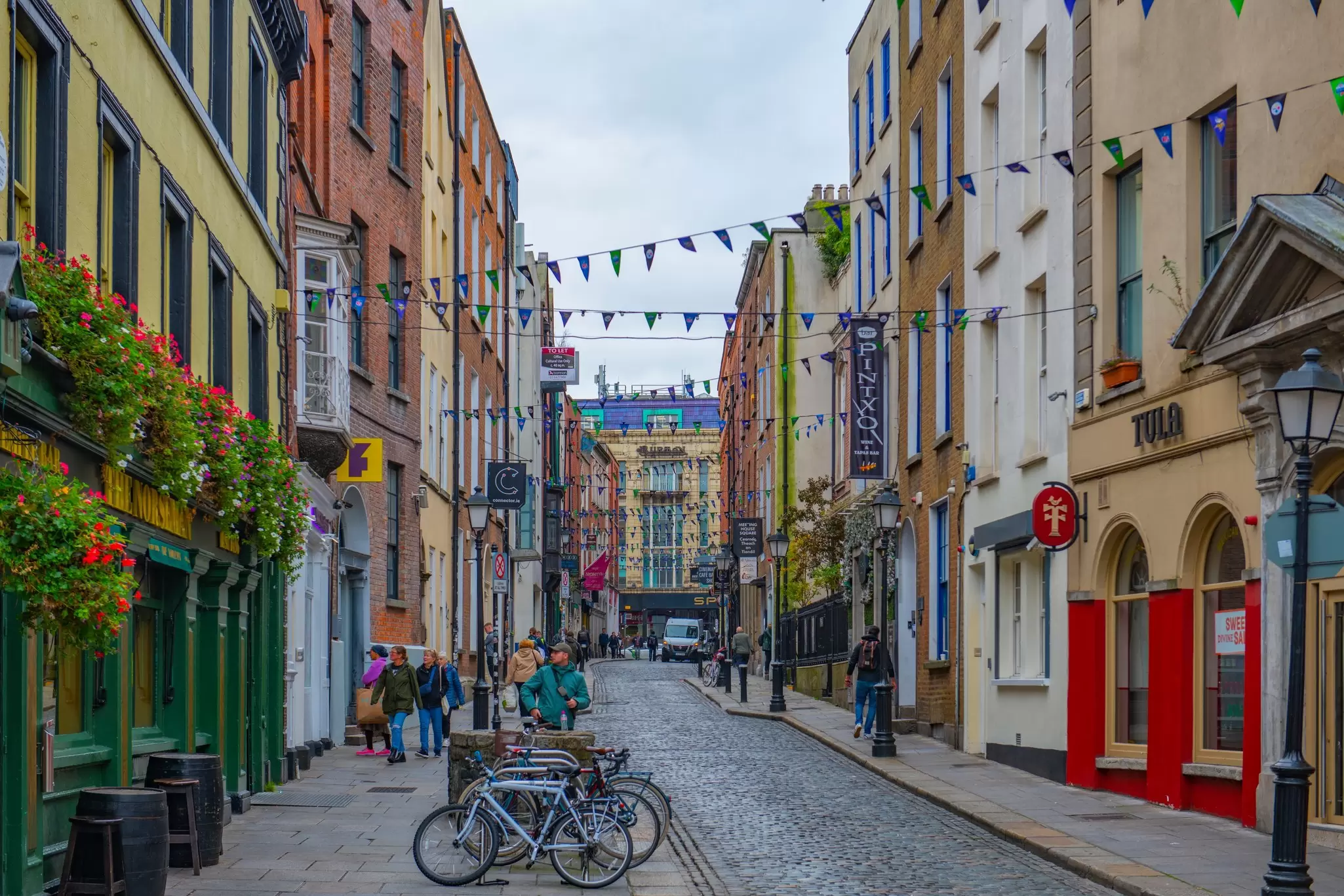 Colorful shops and restaurants line the cobbled Eustace Street in Dublin. 