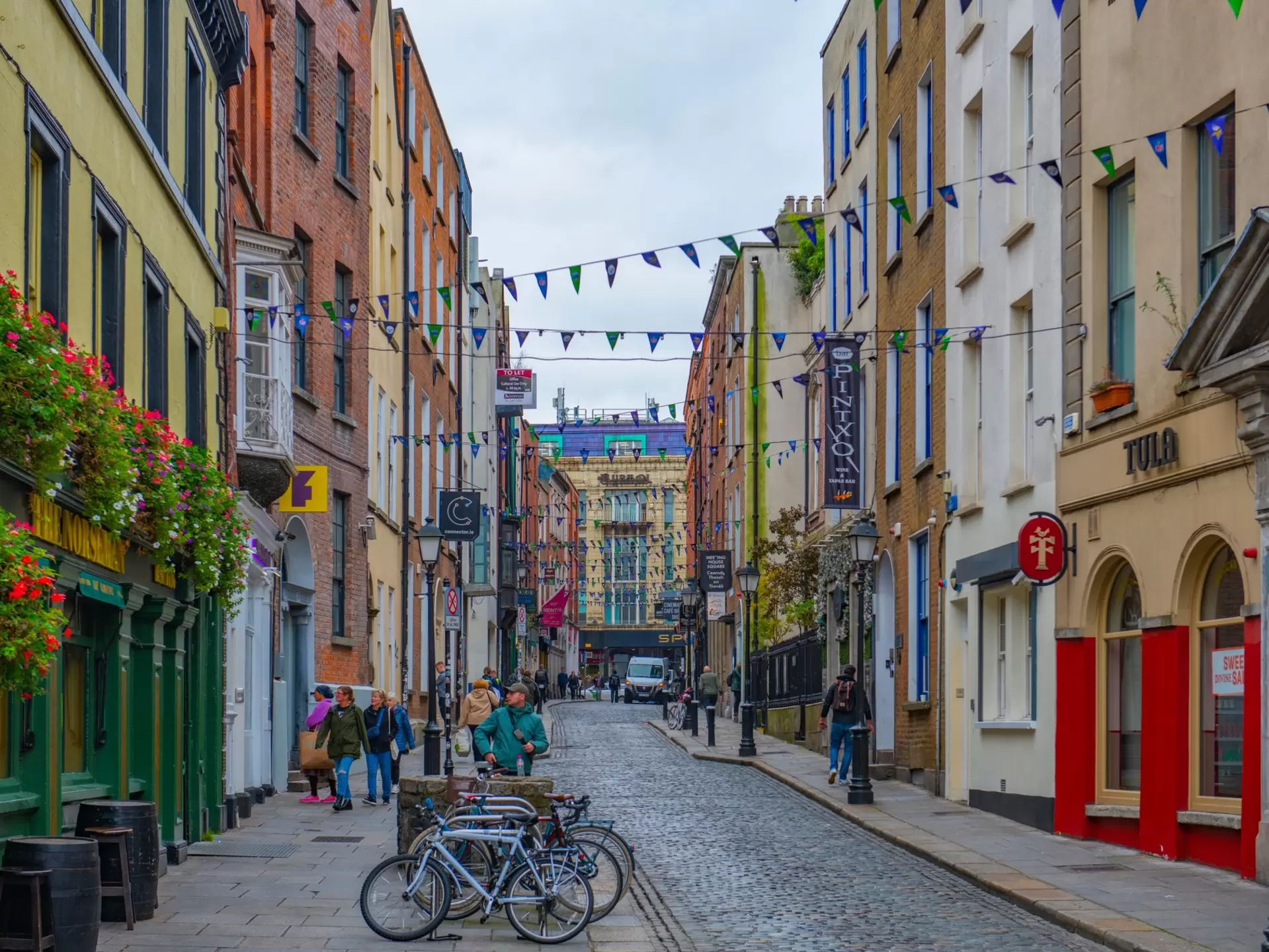 Colorful shops and restaurants line the cobbled Eustace Street in Dublin. 