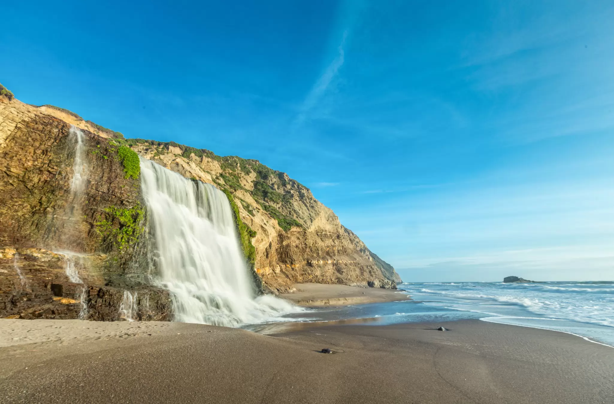 Alamere Falls tumbling down a cliff onto the sandy beach at Point Reyes National Seashore