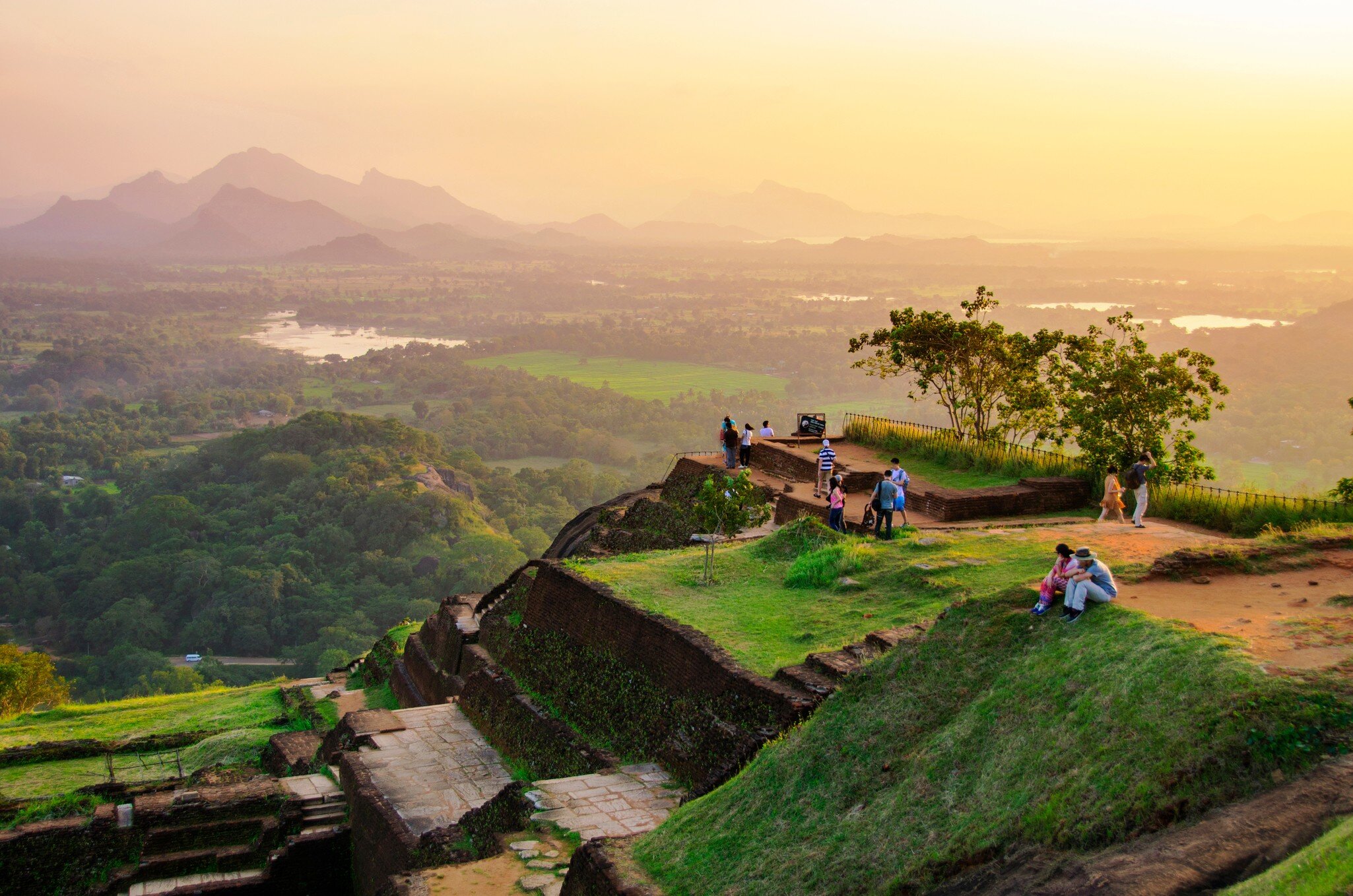 People sitting on Sigiriya Rock in Sri Lanka at sunset.