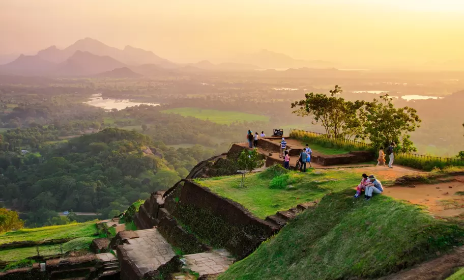 People sitting on Sigiriya Rock in Sri Lanka at sunset.