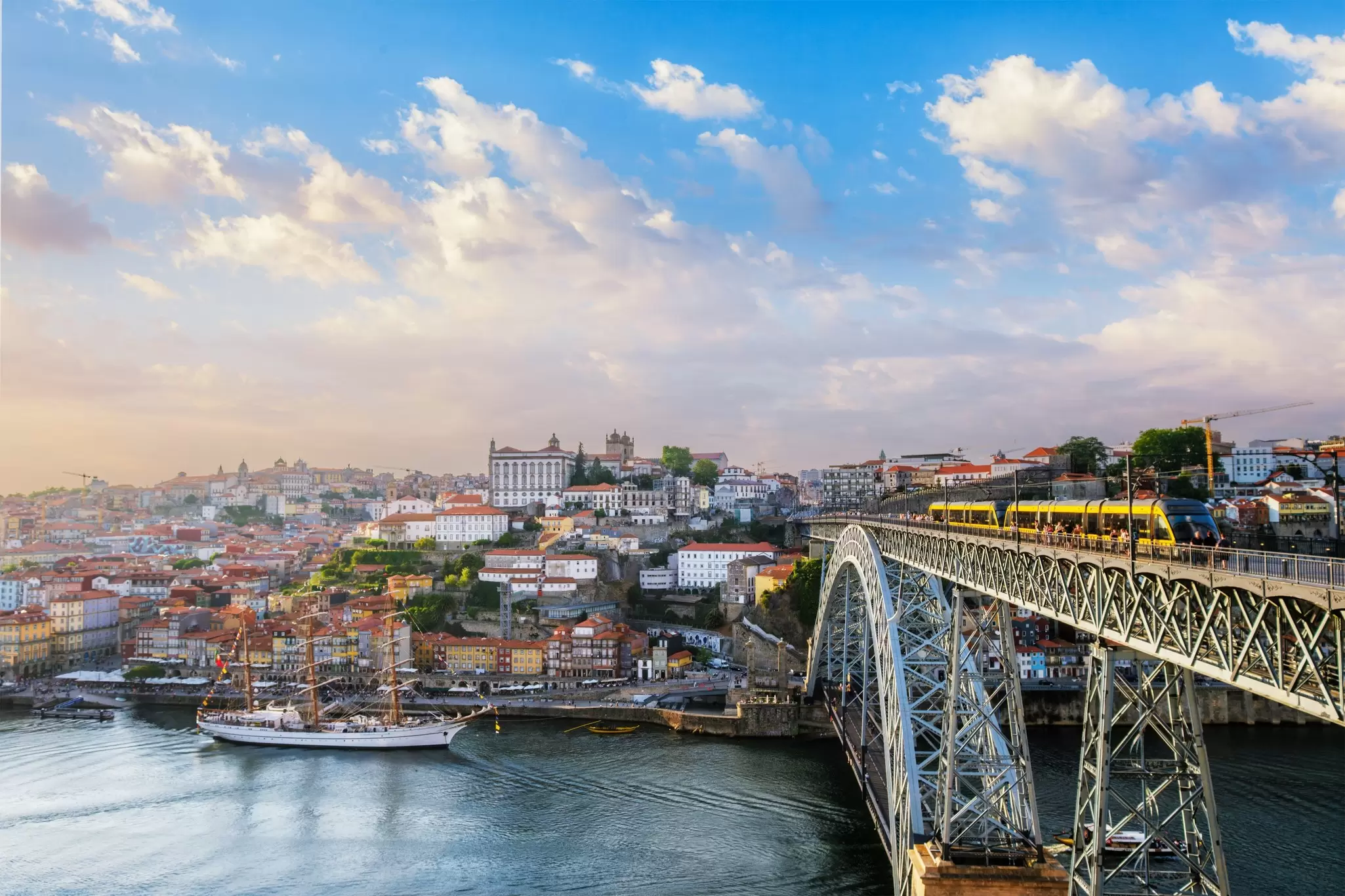 View of Porto city and the Douro River from the famous tourist viewpoint of Miradouro do Jardim do Morro during sunset.