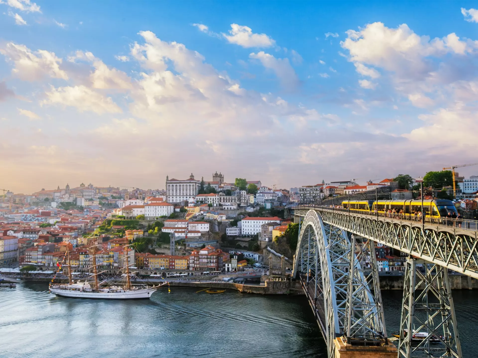 View of Porto city and the Douro River from the famous tourist viewpoint of Miradouro do Jardim do Morro during sunset.