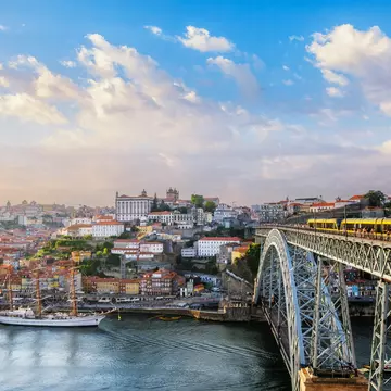 View of Porto city and the Douro River from the famous tourist viewpoint of Miradouro do Jardim do Morro during sunset.
