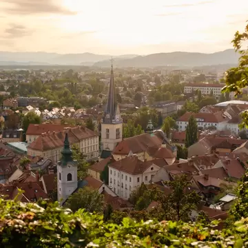view of a church spire and red roof buildings in a vista of Ljubljana