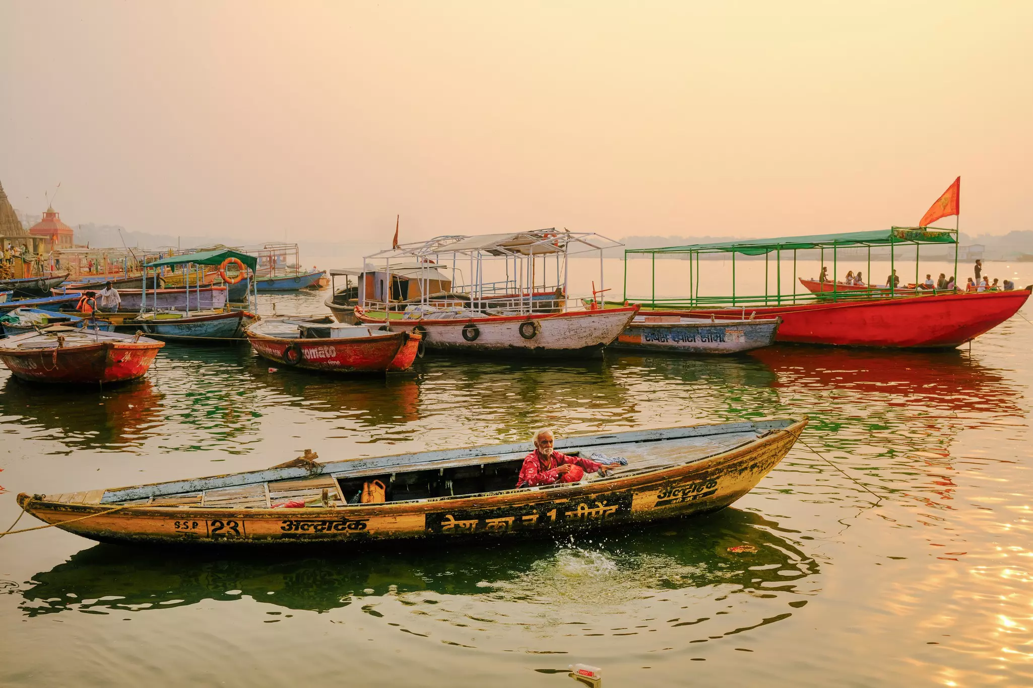 A man in his boat on the Ganges at sunrise.  Varanasi, India