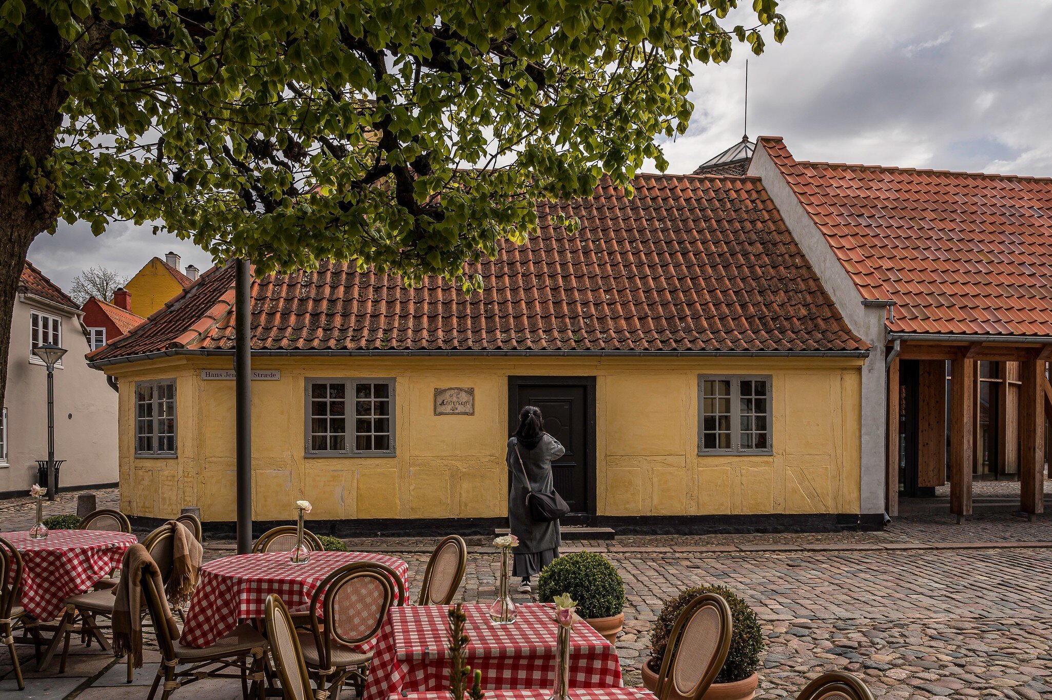Tourist taking a photo at the storyteller H. C. Andersens House in Odense, Denmark.