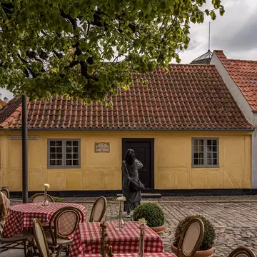 Tourist taking a photo at the storyteller H. C. Andersens House in Odense, Denmark.