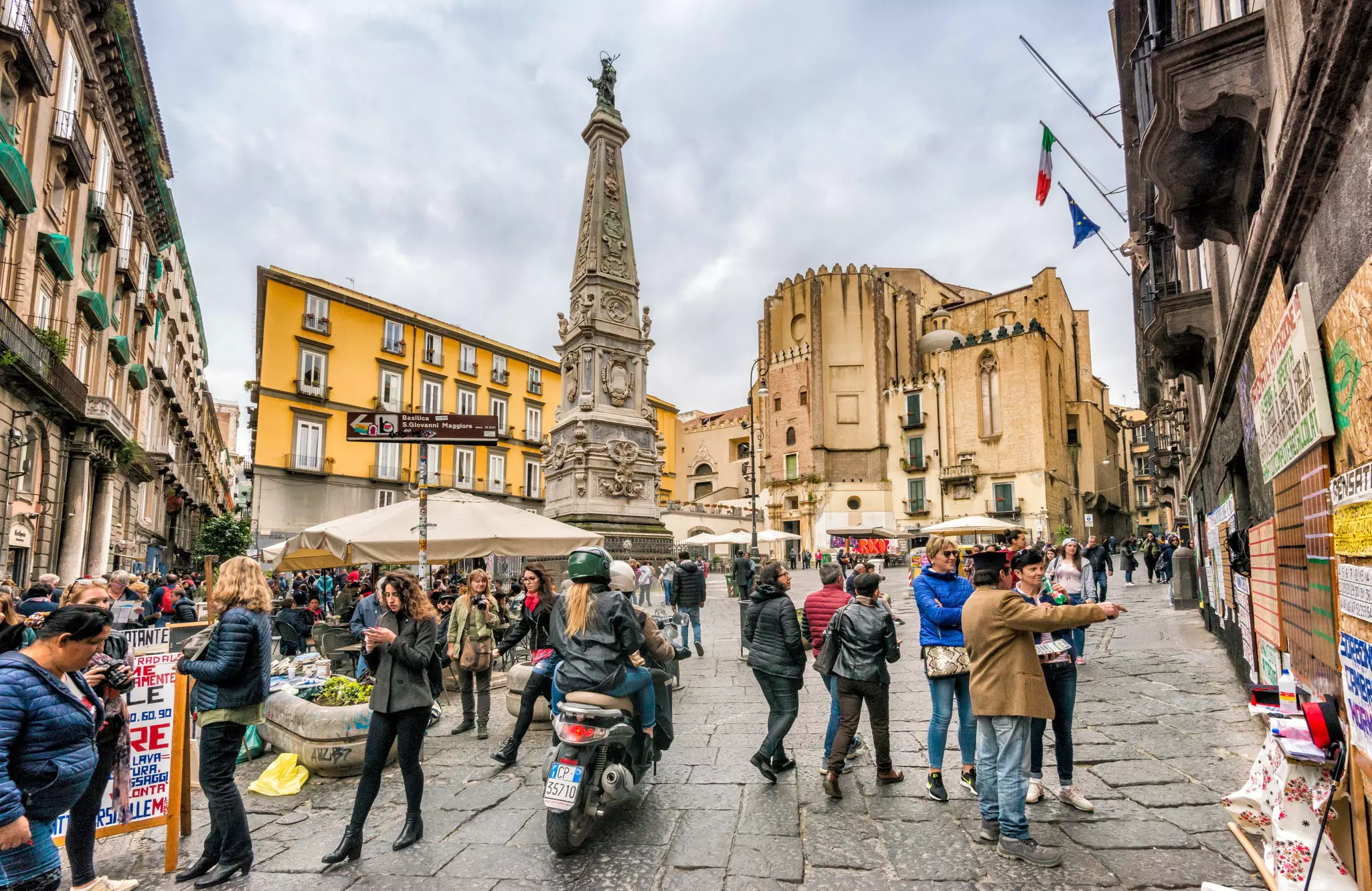 R4TD37 Hustle and bustle around Obelisco San Domenico at Piazza San Domenico Maggiore, Centro Storico quarter, Naples, Campania, Italy