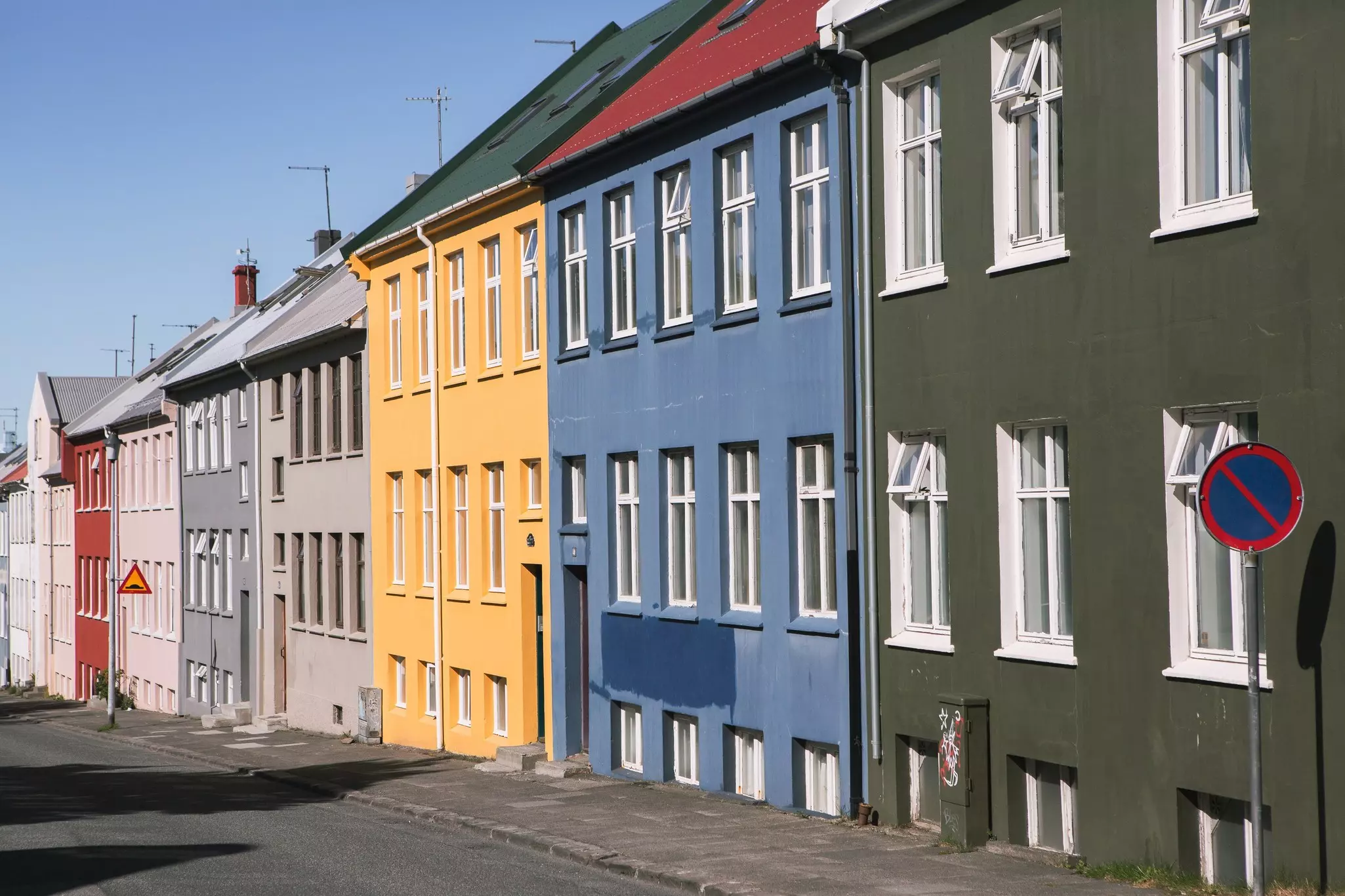 Buildings painted olive green, light blue, yellow, gray, pink and red in Reykjavík, Iceland.