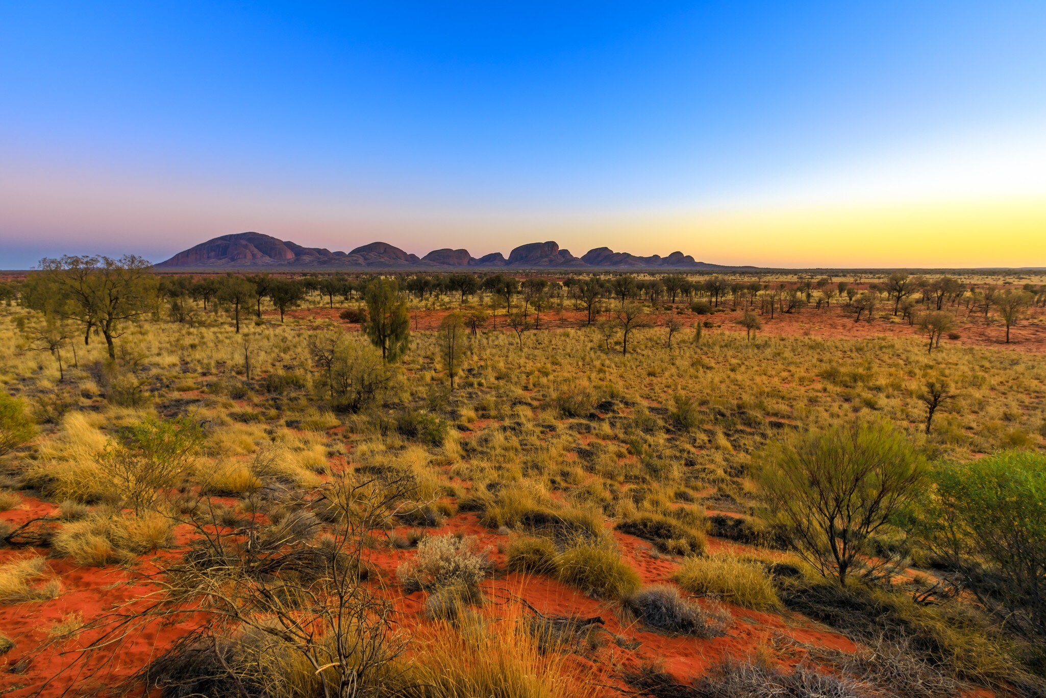 Uluru, Northern Territory, Australia. Sunrise at Kata Tjuta domed rock formation in Uluru-Kata Tjuta National park. Majestic Australian outback from platform dune viewing area at dawn.