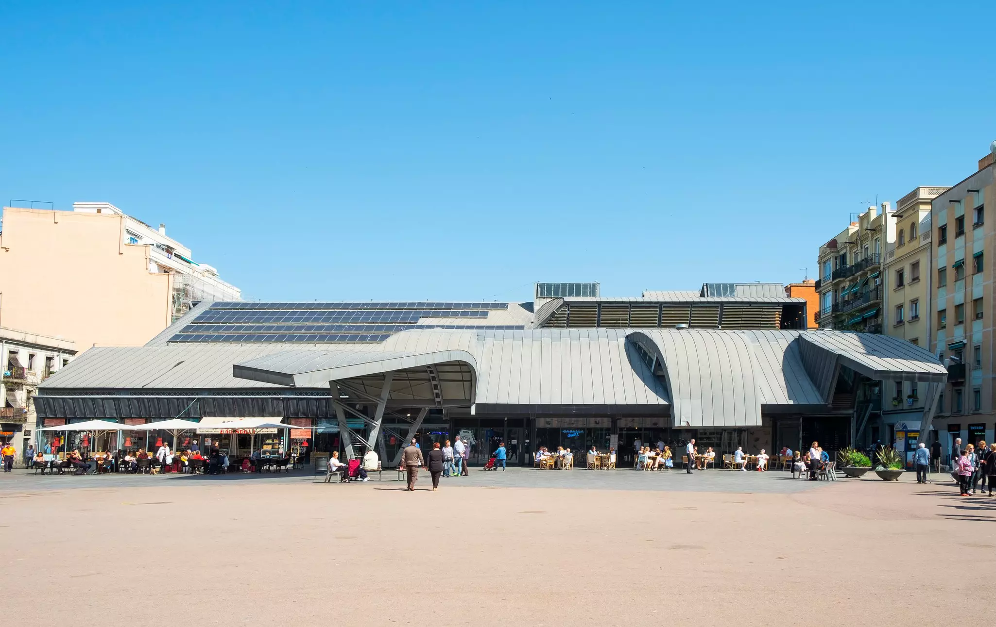 A view of the facade of a seafood market with a curved and sloping roof.