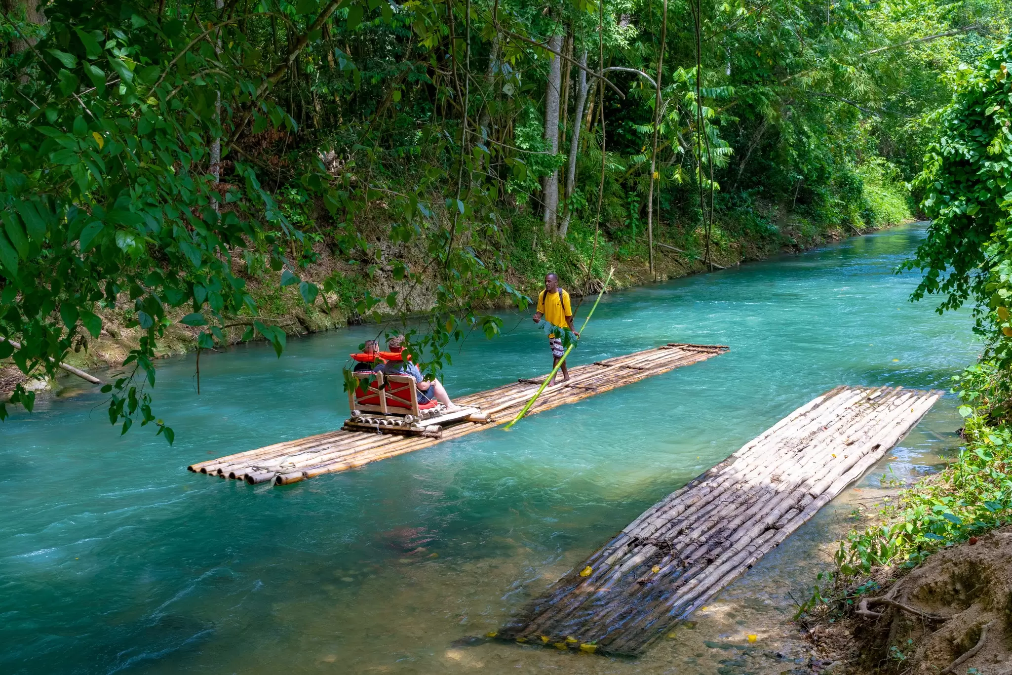 Falmouth, Jamaica - July 07 2019: Martha Brae River, Jamaica. Tourists on bamboo raft rides. Relaxing scenic tour in countryside landscape under canopy trees. People enjoy summer vacation activity.  License Type: media  Download Time: 2023-08-21T21:29:38.000Z  User: claramonitto  Is Editorial: Yes  purchase_order:   