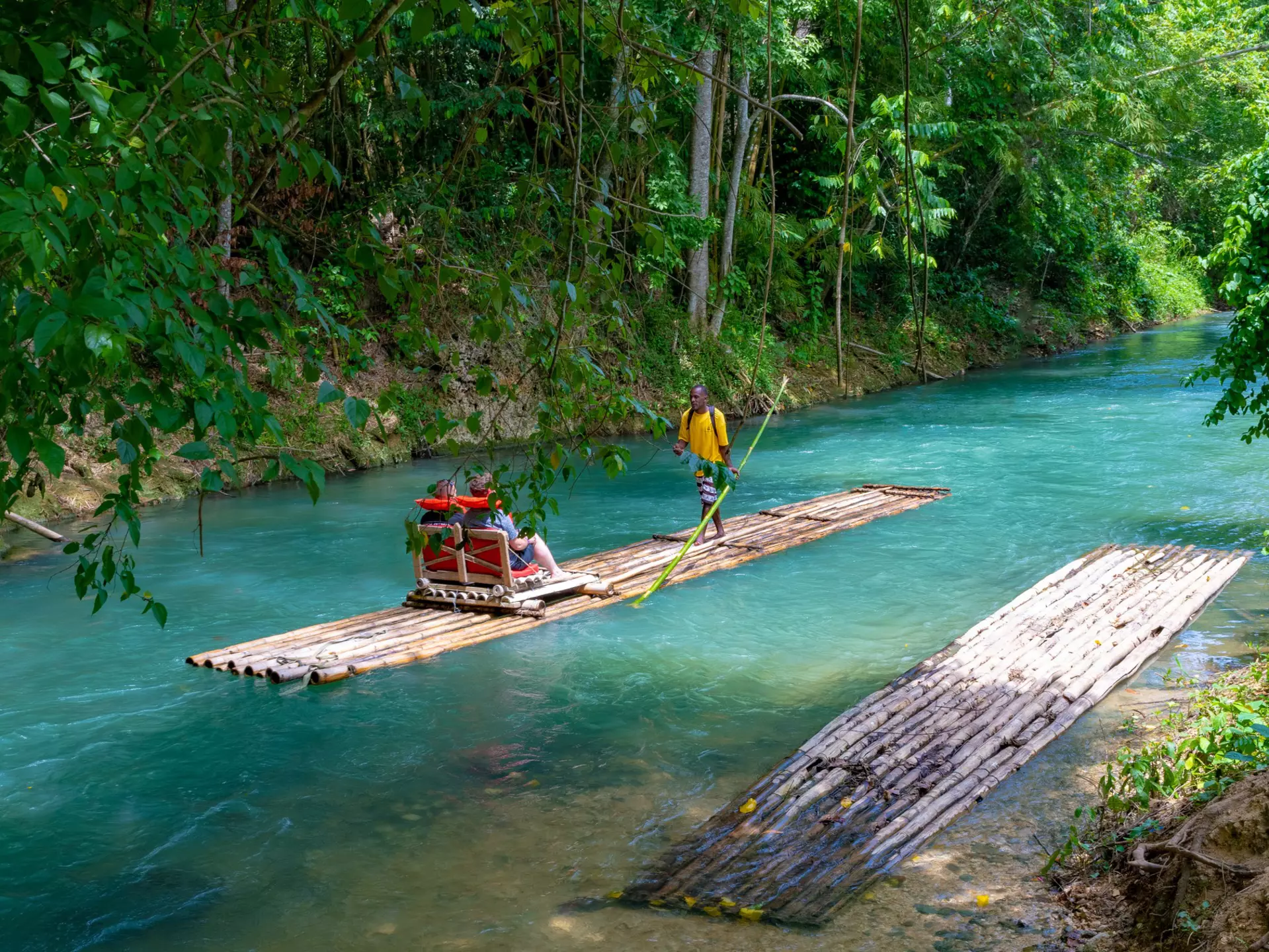 Falmouth, Jamaica - July 07 2019: Martha Brae River, Jamaica. Tourists on bamboo raft rides. Relaxing scenic tour in countryside landscape under canopy trees. People enjoy summer vacation activity.  License Type: media  Download Time: 2023-08-21T21:29:38.000Z  User: claramonitto  Is Editorial: Yes  purchase_order:   