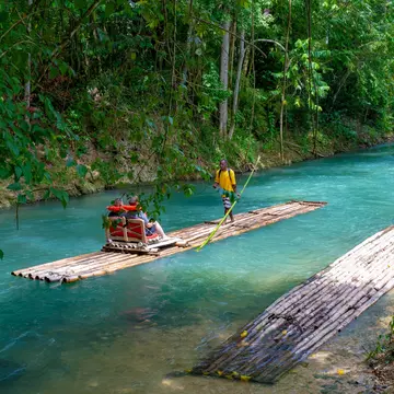 Falmouth, Jamaica - July 07 2019: Martha Brae River, Jamaica. Tourists on bamboo raft rides. Relaxing scenic tour in countryside landscape under canopy trees. People enjoy summer vacation activity.  License Type: media  Download Time: 2023-08-21T21:29:38.000Z  User: claramonitto  Is Editorial: Yes  purchase_order:   