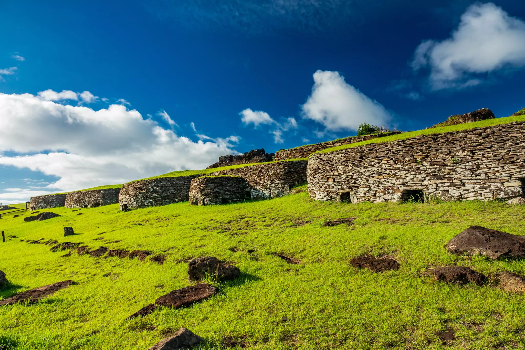 Traditional stone huts under a blue sky at Orongo, Rapa Nui (Easter Island), Chile.