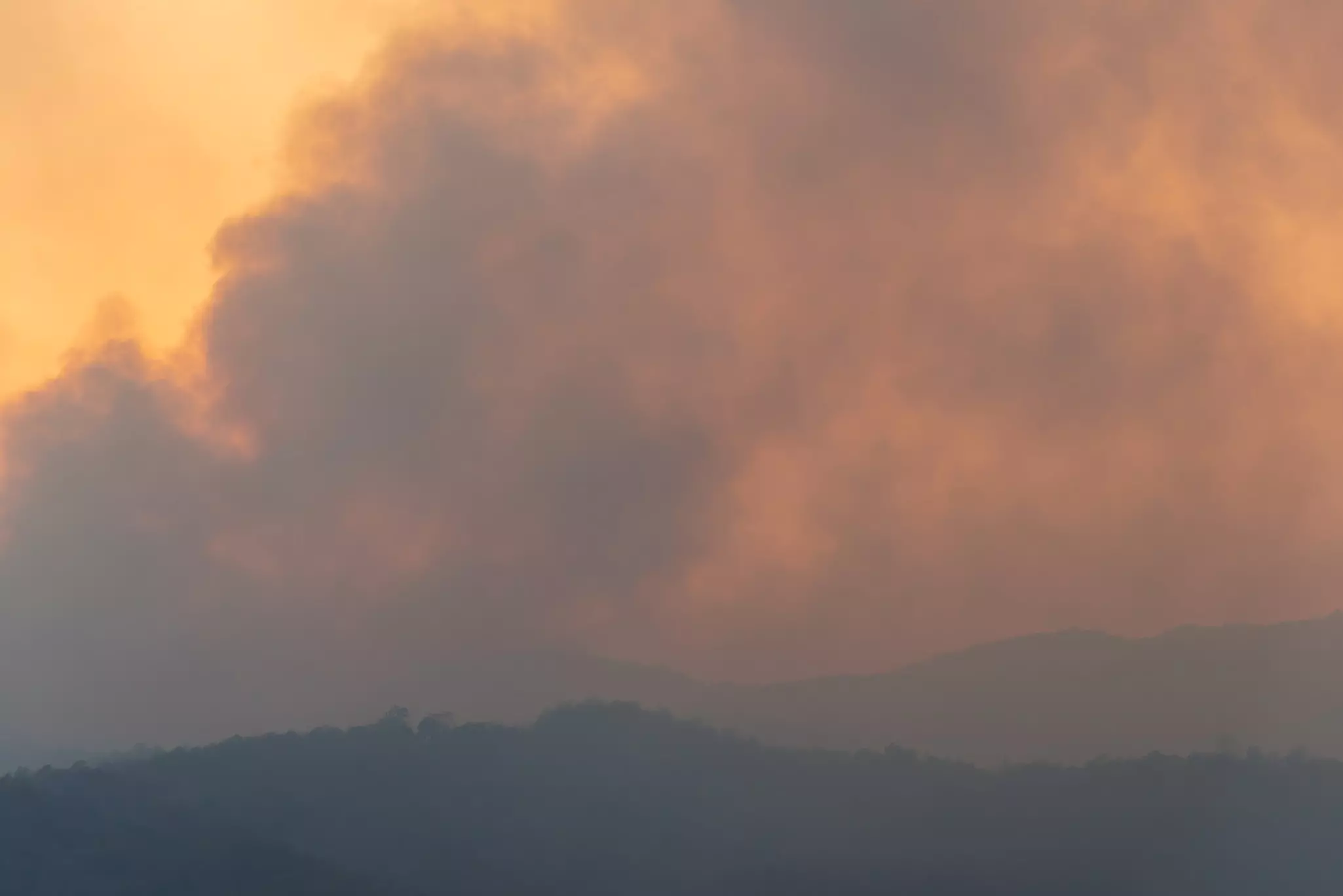 A mountain range surrounded by smoke and fog.