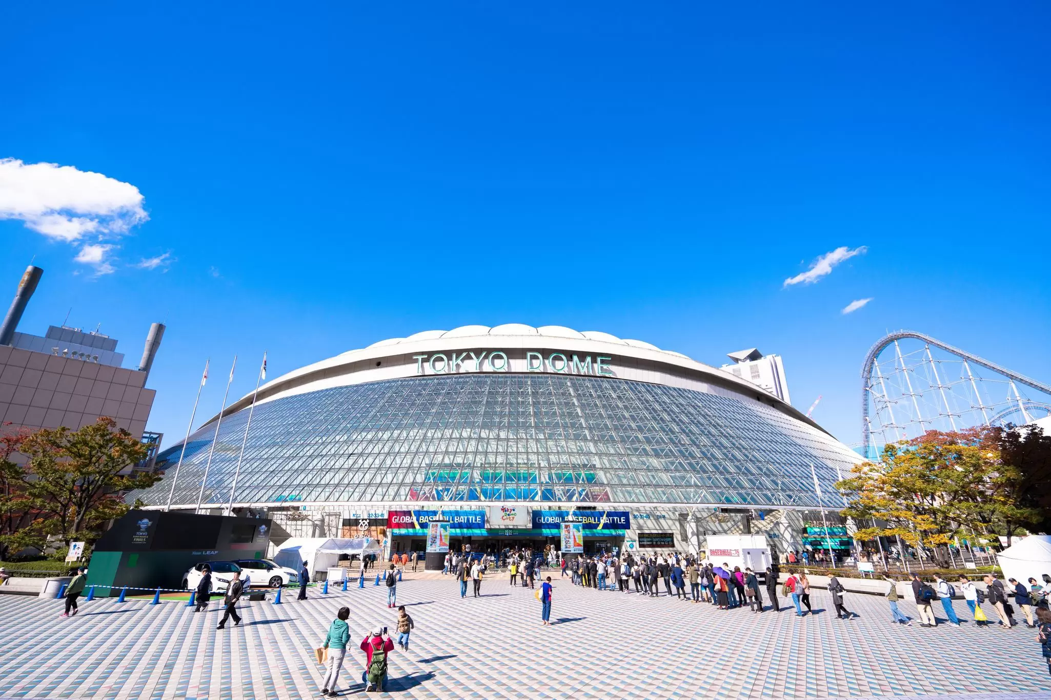 Crowds of people outside the entrance to the Tokyo Dome, a stadium in Bunkyo, Tokyo, Japan.