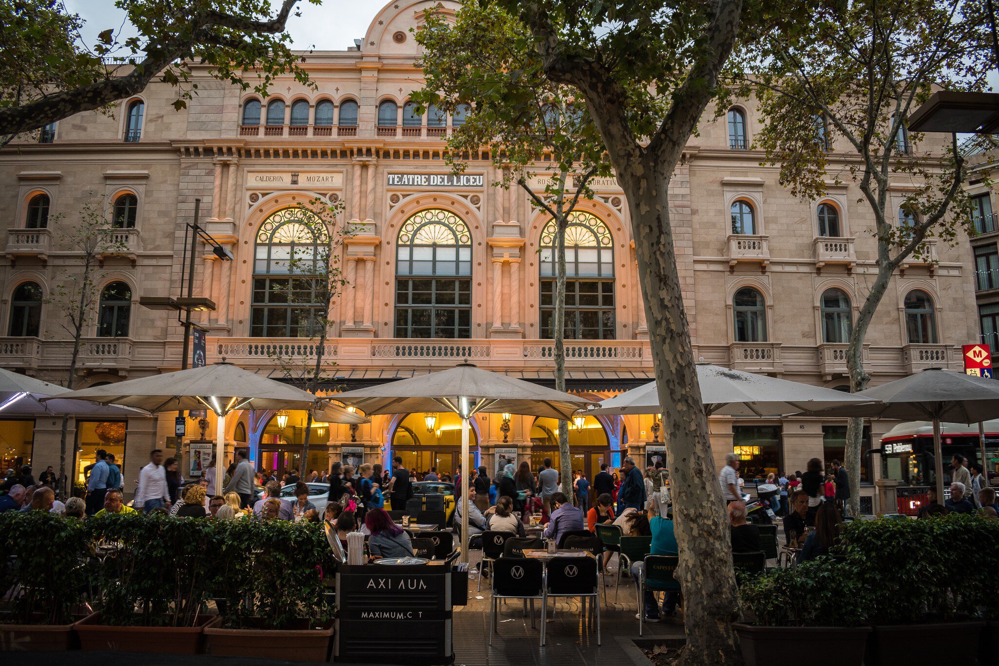 People dining at night outside the Liceu theater facade in Barcelona