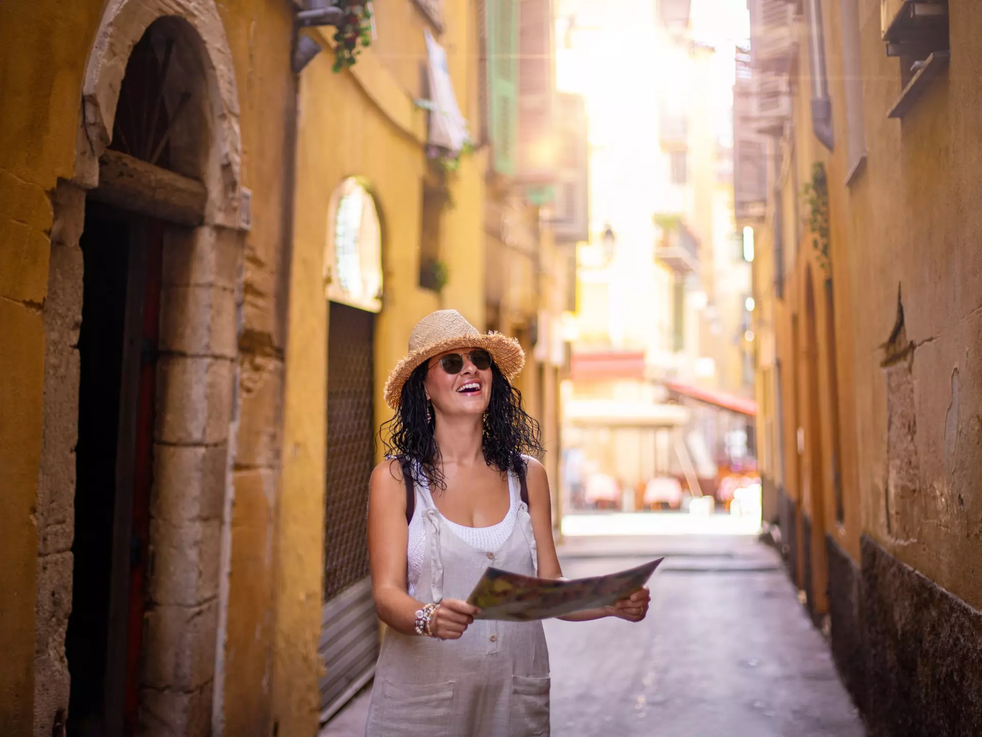 A woman walking along a narrow street in the old town of Nice in France.