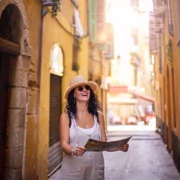 A woman walking along a narrow street in the old town of Nice in France.