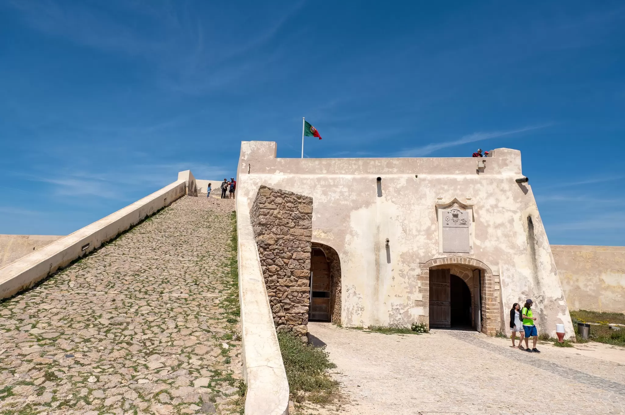 People walking through the Fortaleza de Sagres in the summer in Portugal.