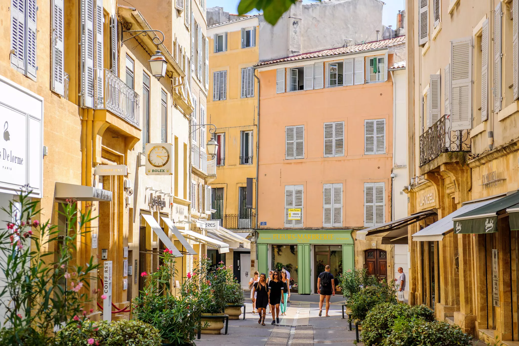 People walking along the shop-lined Rue Nazareth in Aix-en-Provence. 