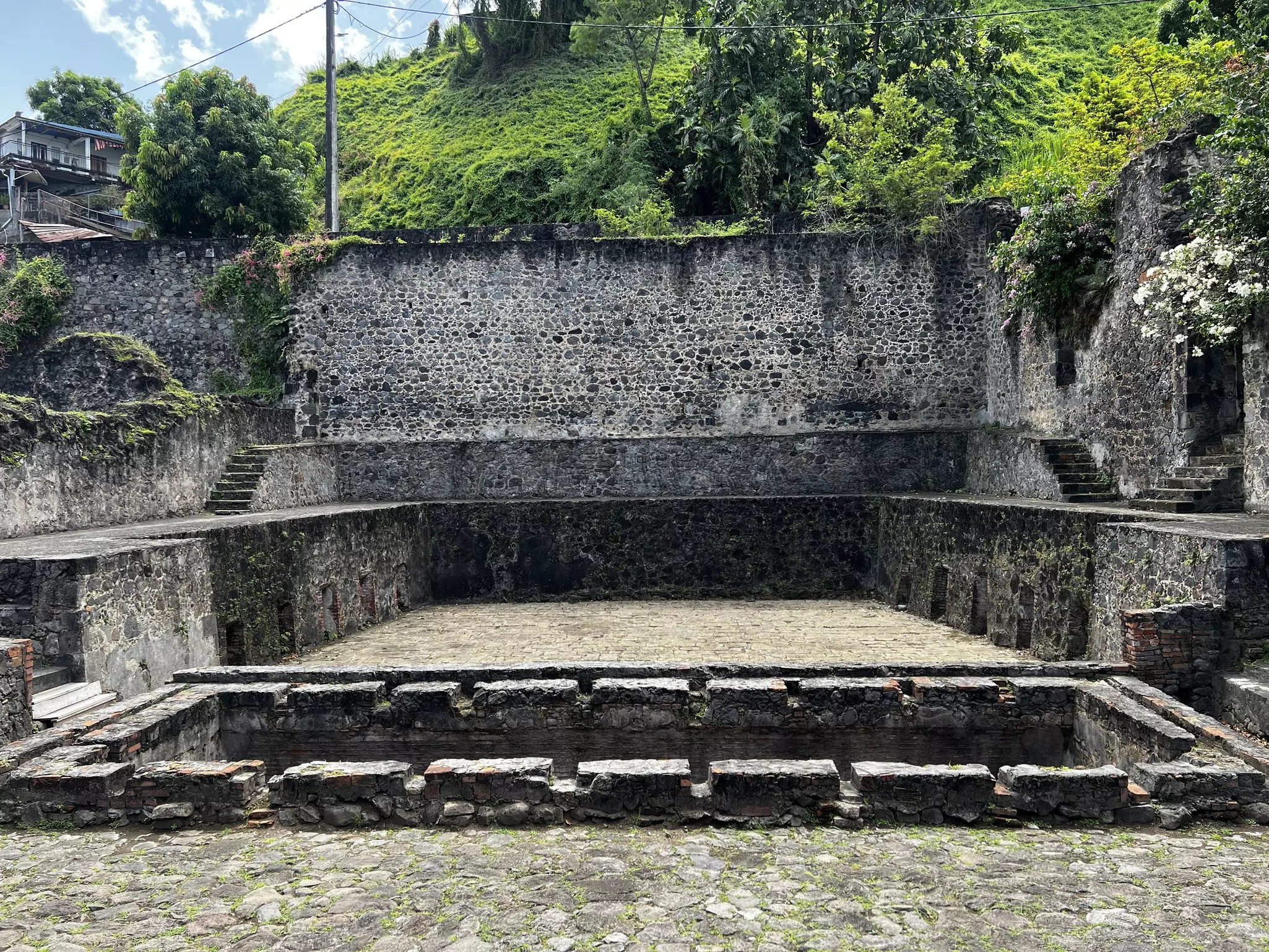 A series of ruined brick walls in the shape of a large rectangular building.