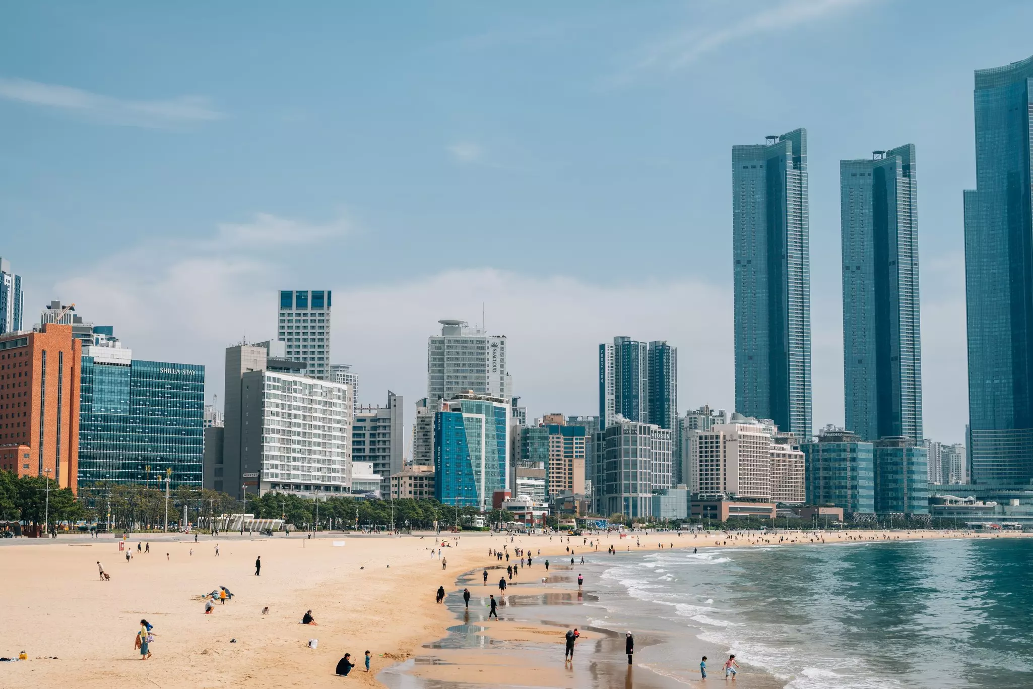 People on a city beach overlooked by skyscrapers