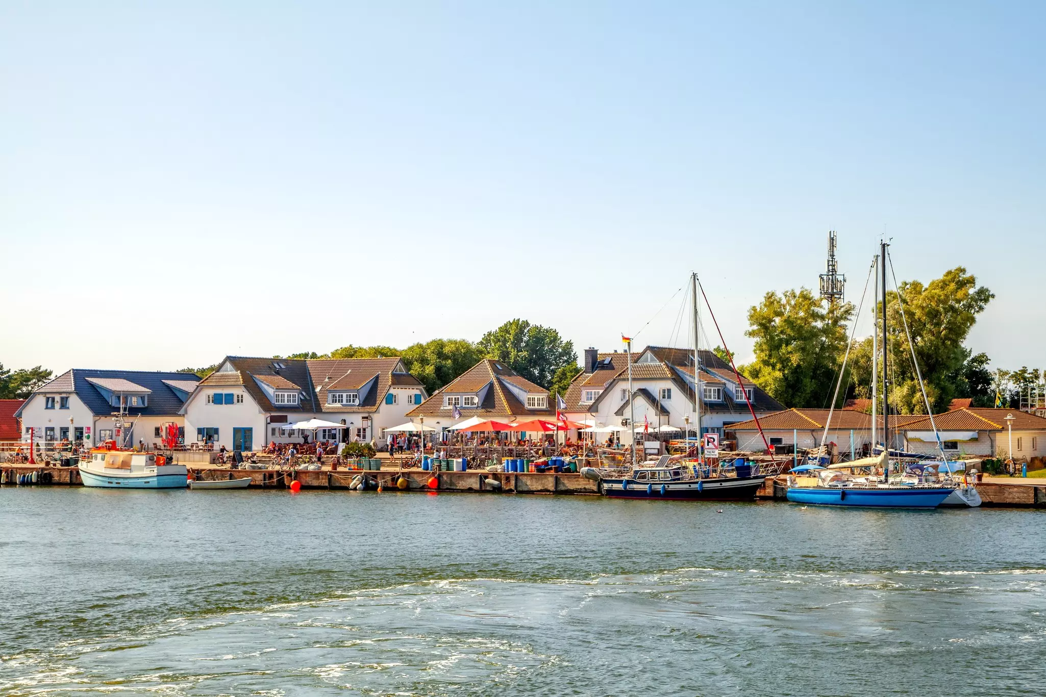 A seaport dock lined with boats and and people