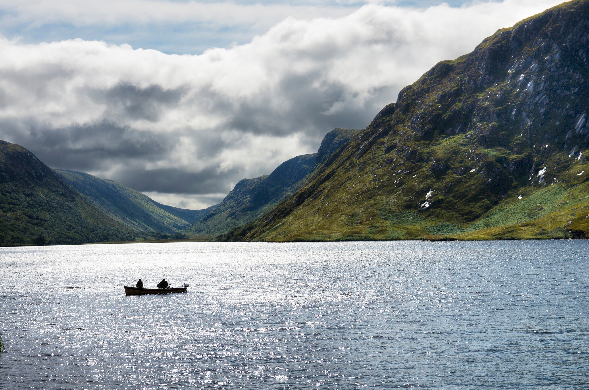 Two people on a boat sailing in the Glenveagh National Park